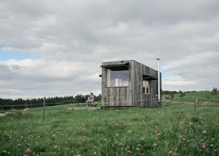Exterior of the glamping tiny house at Na Malém Háji in summer sunshine