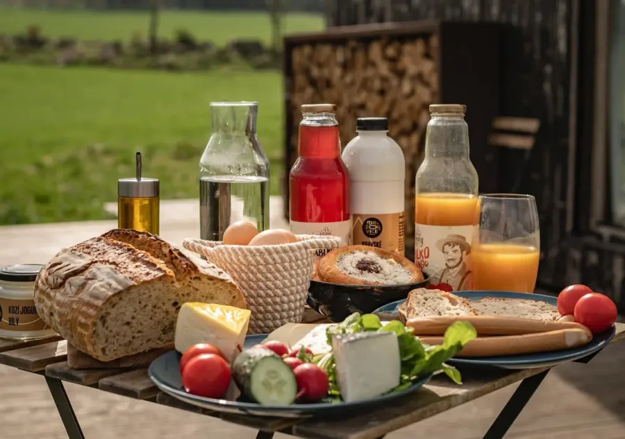 Frühstückskorb voller lokaler Delikatessen – frisches Brot, Käse, Eier und saisonales Gemüse