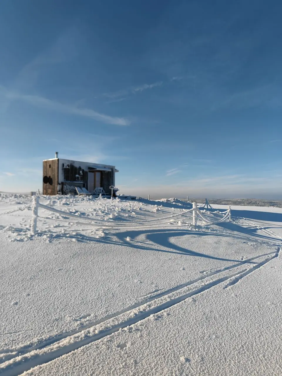 Exterior of the snow-covered glamping tiny house – winter romance