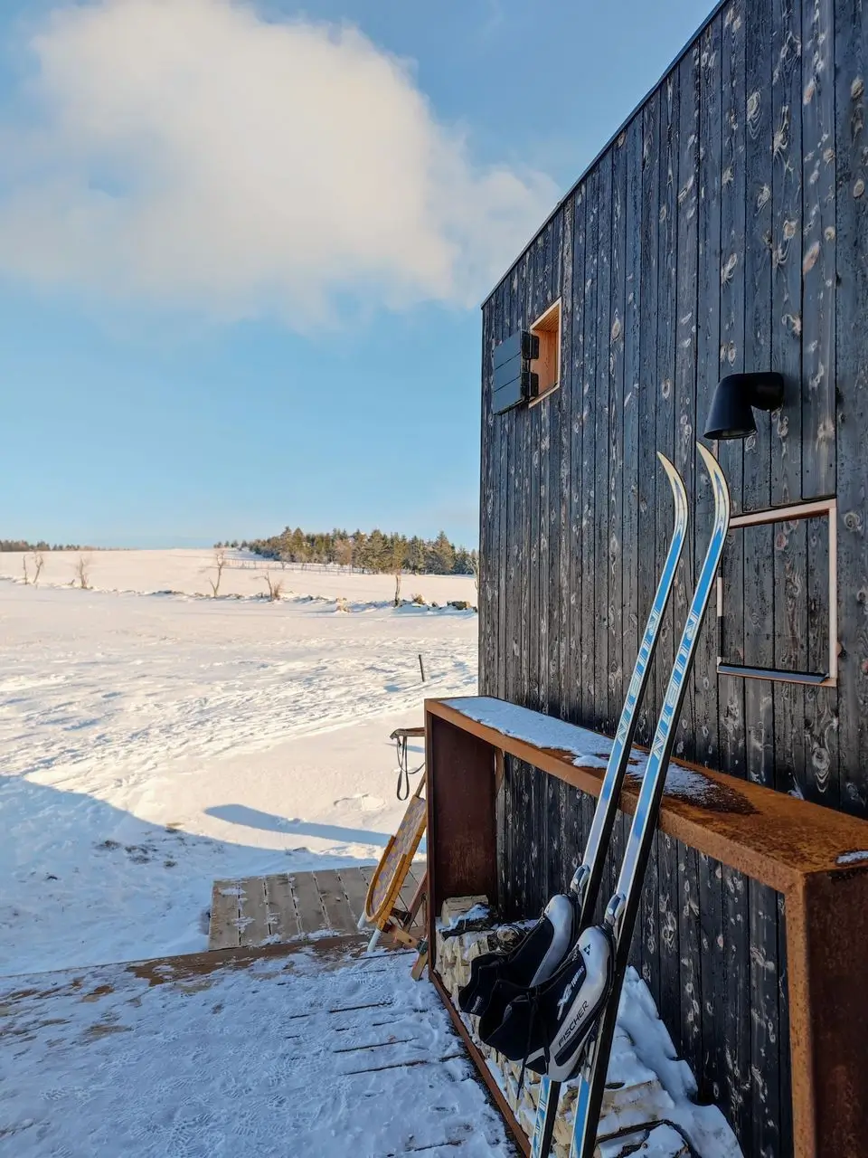 Winter view through the window of the glamping tiny house onto the snowy mountains