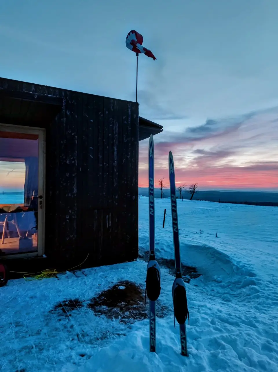 Winter evening at the glamping tiny house – lights in the frost
