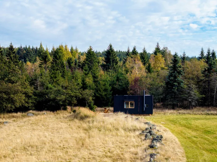 Tiny house U Lesa na podzimní louce na kraji smrkového lesa