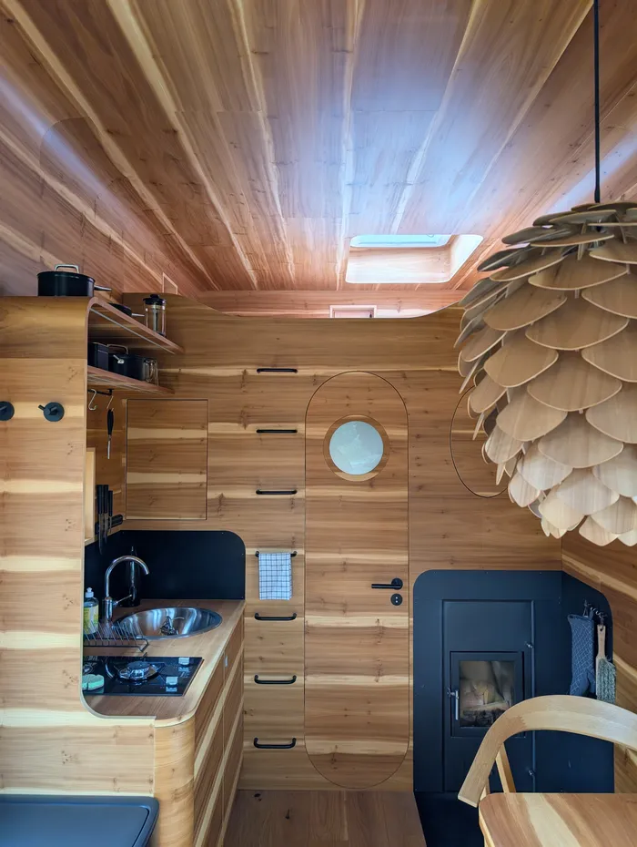 Kuchyň se světlíkem a lampou ve tvaru šišky v tiny house U Lesa