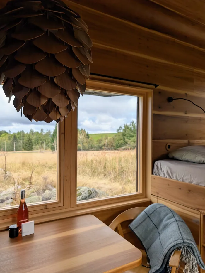 Jídelní stůl u okna s výhledem na louku v tiny house U Lesa