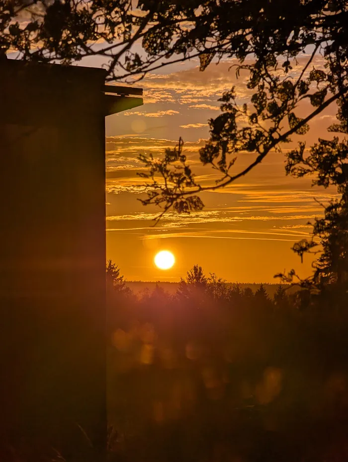 Slunce těsně nad obzorem vedle tiny house U Lesa