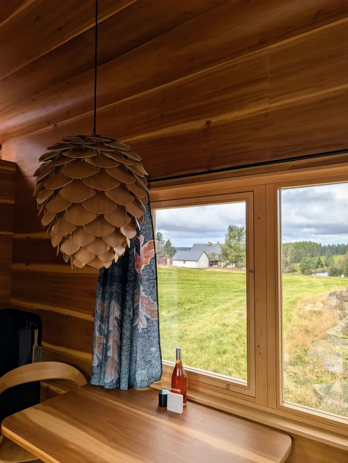 Lampa ve tvaru šišky a výhled z okna tiny house U Lesa