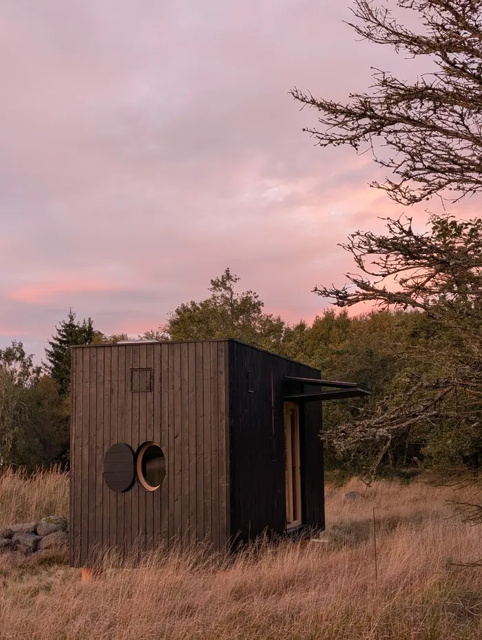 Kulatá okna tiny house U Lesa pod růžovým nebem