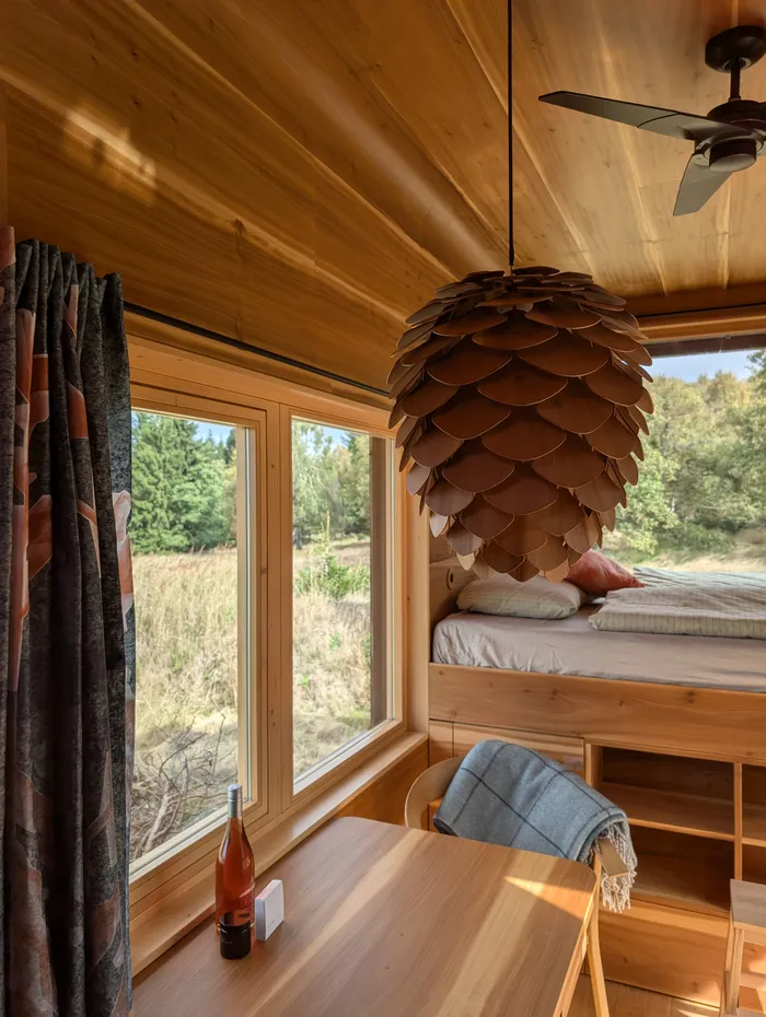 Ložnice tiny house U Lesa se závěsem a velkým oknem
