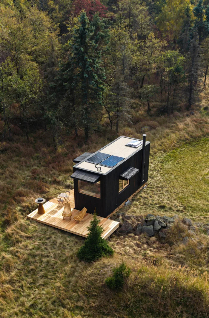 Tiny house U Lesa s terasou na kraji podzimního lesa, pohled z dronu