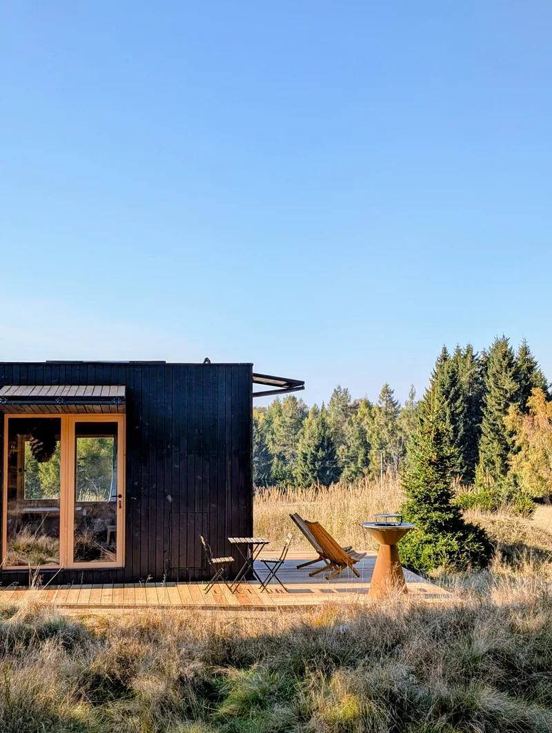Terasa tiny house U Lesa s lehátkem a grilem na podzimní louce u lesa